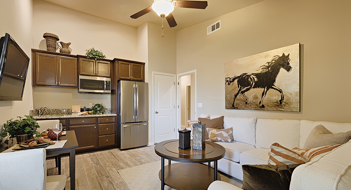 Inside the living room area and kitchenette of The Home Within a Home suite in the Versatillion plan. 