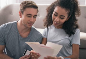 couple on sofa looking over finances