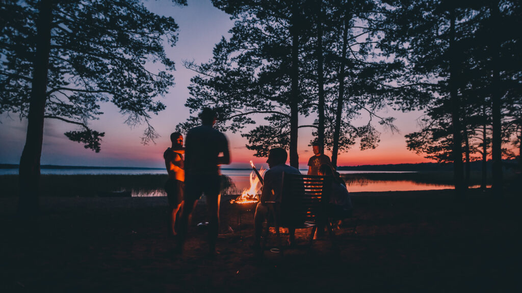 family outside in the summer around a fire