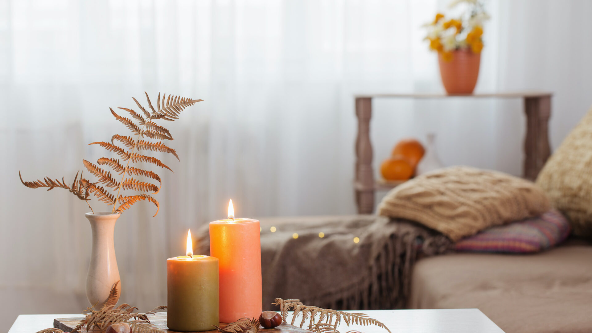 Stock photo of a living area with a coffee table with candles and cozy blankets