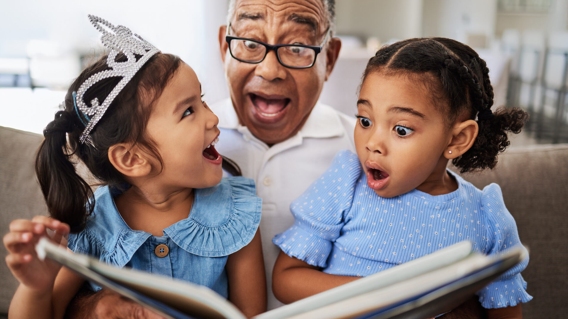Stock photo of grandparent reading to granddaughters