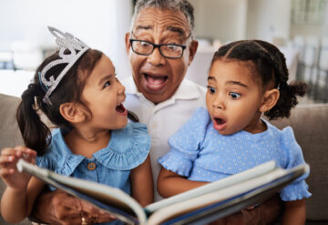 Stock photo of grandparent reading to granddaughters
