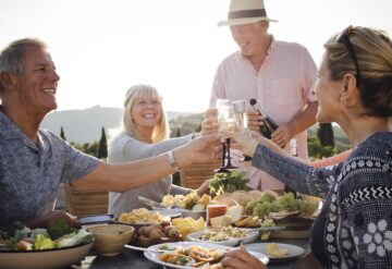 Active Adult Friends Outdoors Dining and toasting